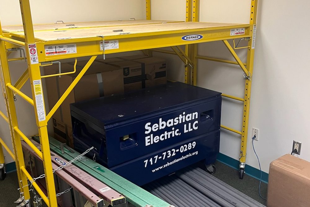 Interior of a room with a ladder and a box of tools on the floor